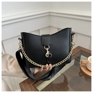 Detail of black faux leather bucket bag with gold chain and adjustable fabric strap