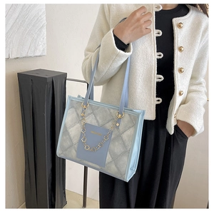 Détail du sac fourre-tout matelassé bleu clair avec chaîne florale dorée sur le mannequin