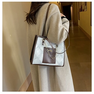 Sac fourre-tout matelassé avec garniture en cuir porté par un modèle pour la taille