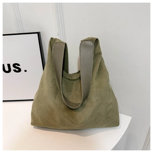 Detailed macro view of moss green suede tote bag with matte texture and wide handle