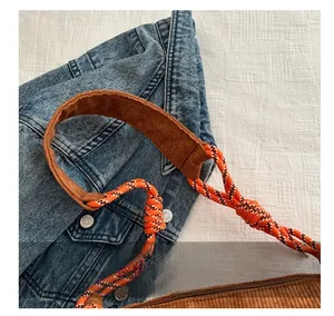 Detail of the corduroy shoulder bag featuring a durable woven rope strap and padded comfort