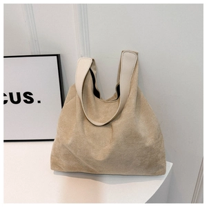Macro shot of beige suede tote bag with white strap on minimalist stage display