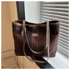 Detail of British vintage plaid tote bag featuring woolen fabric and brown leather straps