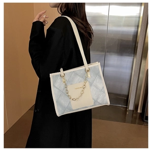 Sac fourre-tout en denim bleu avec bordure en cuir crème et détail de chaîne dorée