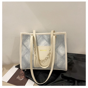 Détail du sac cabas matelassé bleu avec chaîne dorée et poche avant pour le quotidien