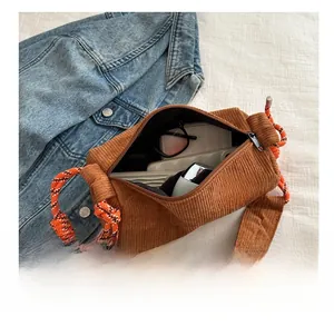 Internal view of brown corduroy cylinder bag with orange rope strap showing spacious capacity