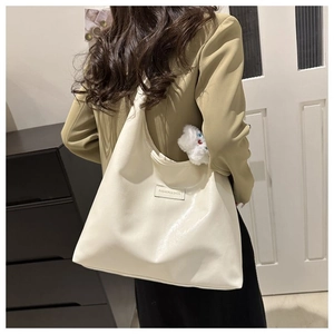 Close-up of beige PU leather tote bag featuring a Fashion & Bags tag and plush cat charm