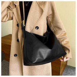 Detail of adjustable shoulder strap with gold hardware on a black leather hobo bag