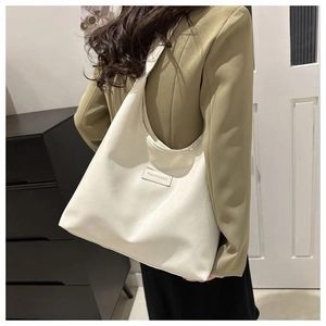 Detail of minimalist beige tote bag with Fashion & Bags leather patch on front