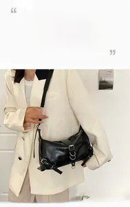 Detail of glossy black PU leather shoulder bag with silver metal rings and buckles