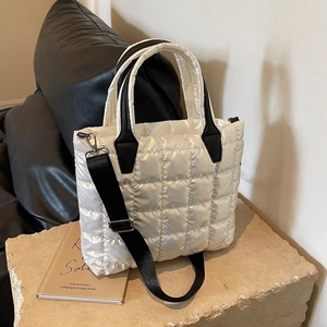 Large white quilted nylon tote bag with black handles and adjustable shoulder strap