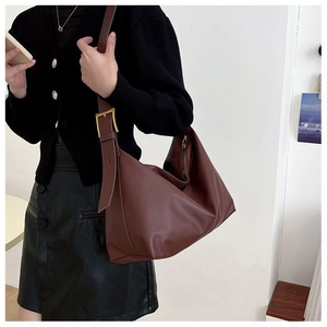 Close-up of brown hobo bag showing the wide strap and golden square metal buckle