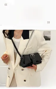 Chic black matte leather shoulder bag with thick silver chain strap worn on a stylish model