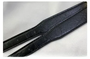 Close-up of black textured leather strap with fine stitching and cracked grain finish