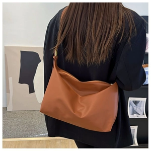 Detailed back view of a soft brown large hobo bag with wide shoulder strap and gold ring