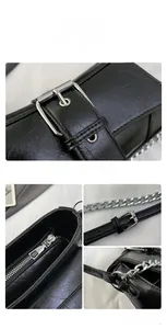 Close-up of black textured leather crossbody bag with silver buckle and chain strap