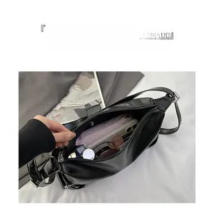 Interior view showing large capacity of the glossy black shoulder bag with daily essentials