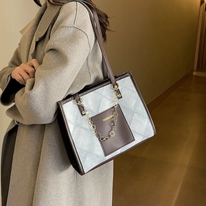 Sac cabas matelassé bleu avec bordure en cuir marron et chaîne florale dorée