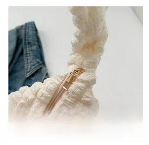 Detail of gold zipper and white popcorn bubble texture fabric on chic tote bag