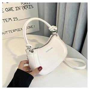 Detail of white half-moon bag featuring knot handle and 'FASHION & BAGS' embossed text