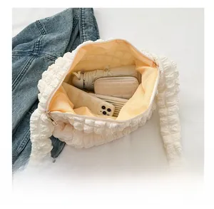 Detail view of large white bubble textured tote bag showing spacious inner yellow lining