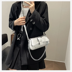 Mirror selfie showing silver metallic chain bag details with pleated texture on black suit