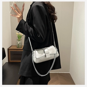 Detail of silver metallic leather handbag with chain strap shown on a model