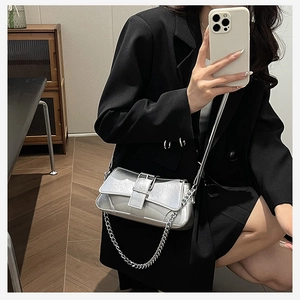 Detailed view of silver baguette bag with chain strap and smooth faux leather texture