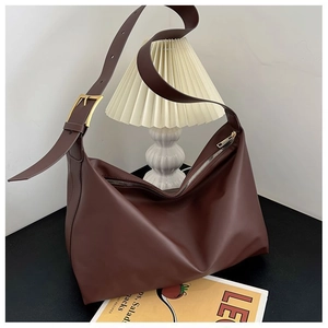 Detail of soft matte leather hobo bag with adjustable gold buckle and wide shoulder strap