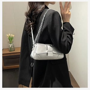 Detail view of silver metallic shoulder bag with thick chain strap and buckle decor
