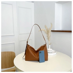 Detailed view of caramel leather tote bag showing smooth texture and adjustable buckle strap
