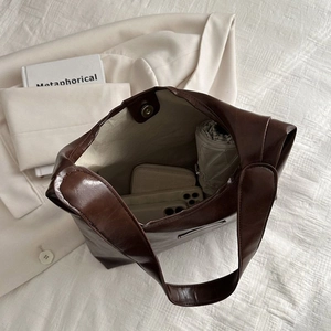 Deep brown leather tote bag showing spacious interior with phone, wallet and umbrella
