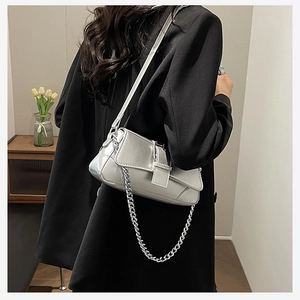 Silver metallic chain bag shown on model wearing black blazer for a premium styling look
