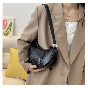 Chic black patent leather crescent shoulder bag with vintage pleats and silver hardware