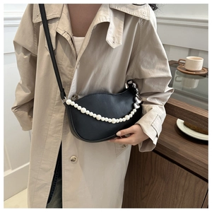 Detail of black crescent moon bag with pearl chain and silver heart charms