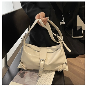 Détail du sac bandoulière vintage crème en cuir texturé avec boucles métalliques argentées