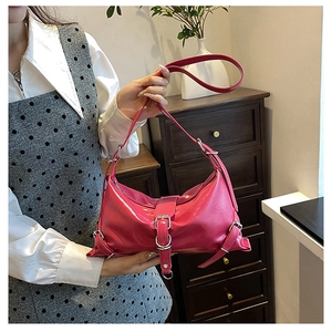 Détail du sac à bandoulière en cuir rose rouge avec finition brillante et boucle