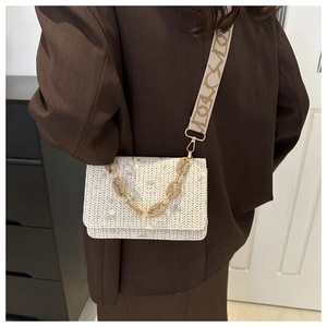 Detail of cream woven bag with floral embroidery and resin chain strap detail