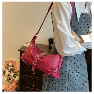 Detail of rose pink faux leather underarm bag with silver buckles and zipper