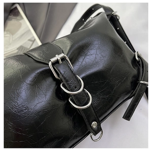 Détail de cuir craquelé noir avec boucles métalliques argentées et anneaux décoratifs