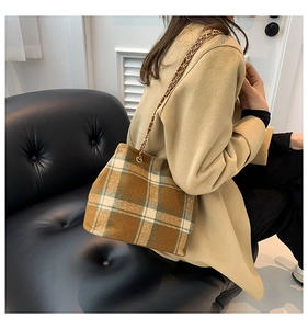 Close-up of model wearing a vintage plaid chain bucket bag in wool material