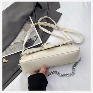 Close-up of off-white PU leather handbag with wrinkled texture and silver chain strap