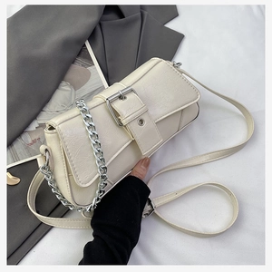 Close-up of cream crossbody bag featuring textured leather and large silver buckle