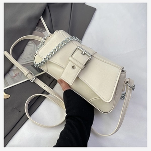 Detail of off-white rectangle crossbody bag with crackle texture and silver chain