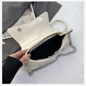 Detailed interior of cream white crossbody bag showing silver magnetic closure and black lining