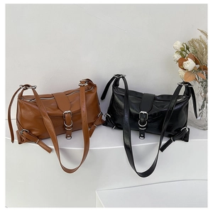 Gros plan de sacs bandoulière en similicuir marron et noir avec détails d'œillets en métal