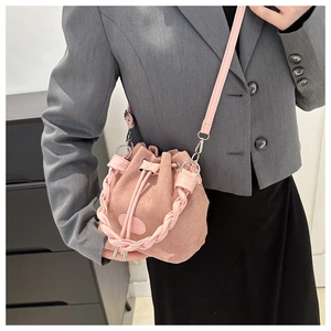 Detail view of pink frosted suede bucket bag with braided handle and drawstring closure