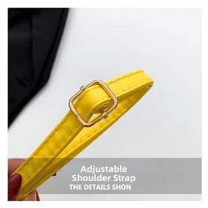 Detail of adjustable yellow leather shoulder strap with gold metal buckle and stitching