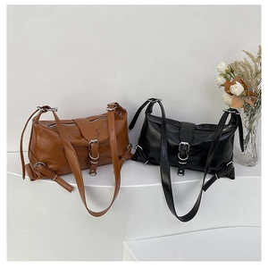 Gros plan de sacs bandoulière en cuir brillant vintage avec boucles en métal argenté