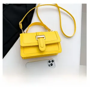 Detail of yellow crocodile pattern leather bag with gold buckle and adjustable strap
